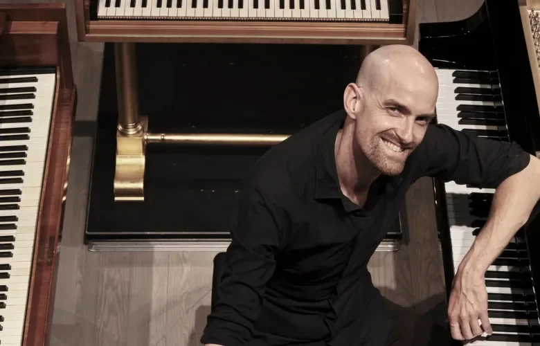 Anthony Romaniuk surrounded by pianos