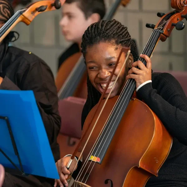 meisje speelt cello en lacht