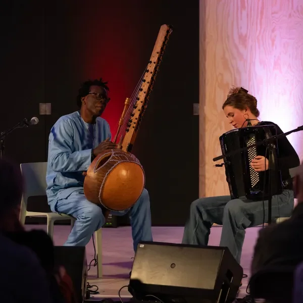 man speelt Kora (een Afrikaanse harp), jonge vrouw speelt accordeon